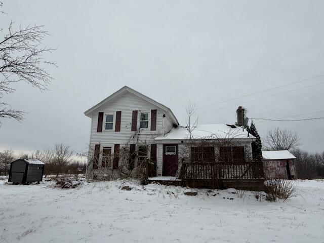 traditional home featuring a shed and an outbuilding