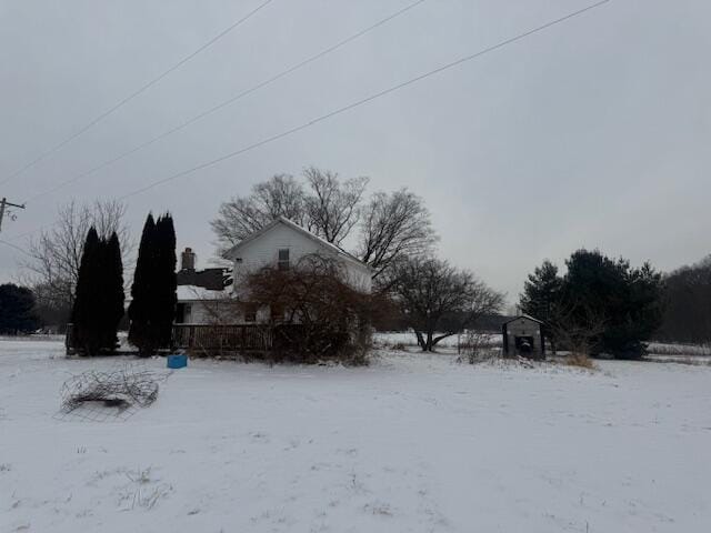 yard covered in snow with a storage shed and an outdoor structure