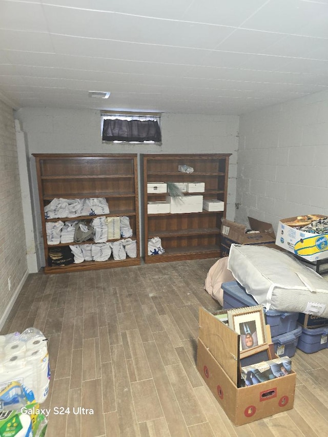 bedroom featuring wood finished floors and concrete block wall