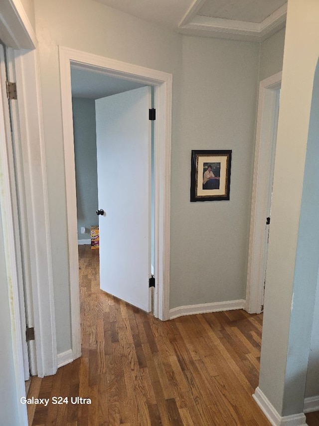 hallway featuring baseboards and wood finished floors