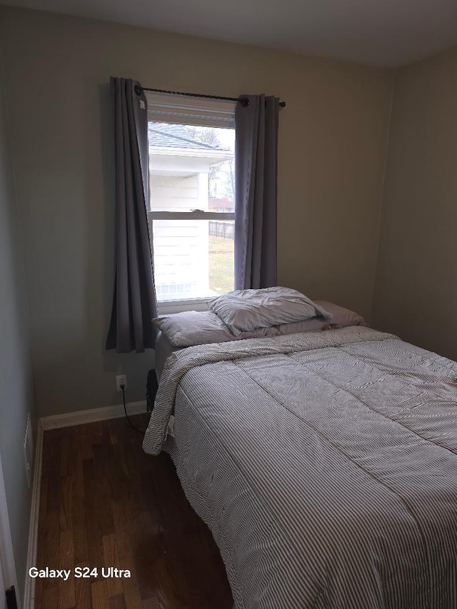 bedroom with baseboards and wood finished floors