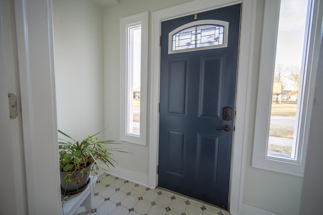 entrance foyer featuring light floors and baseboards