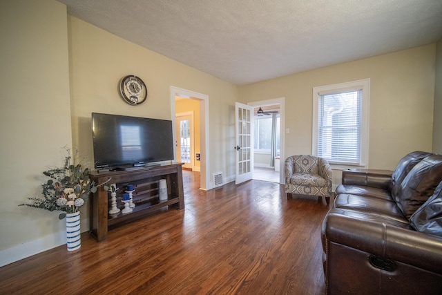 living room featuring baseboards, visible vents, wood finished floors, a textured ceiling, and french doors