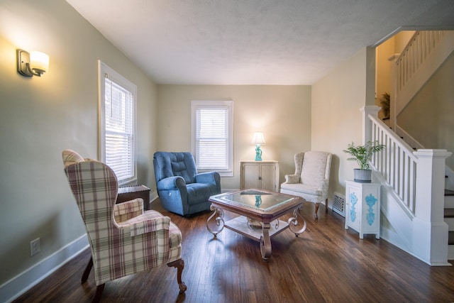 living area with baseboards, stairs, visible vents, and wood finished floors