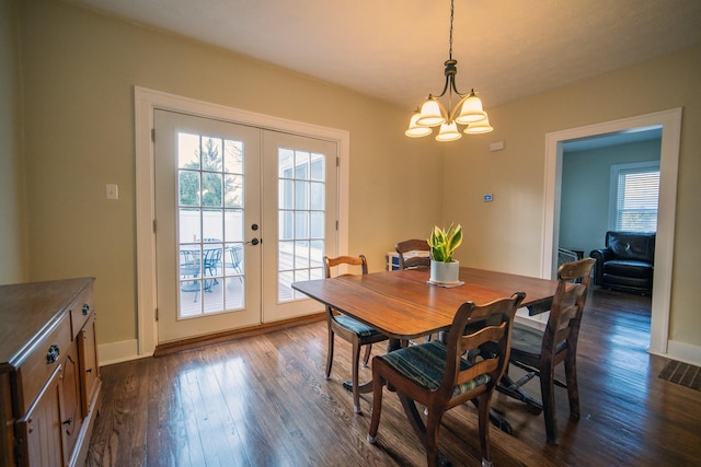 dining room featuring dark wood-type flooring, french doors, a healthy amount of sunlight, and visible vents