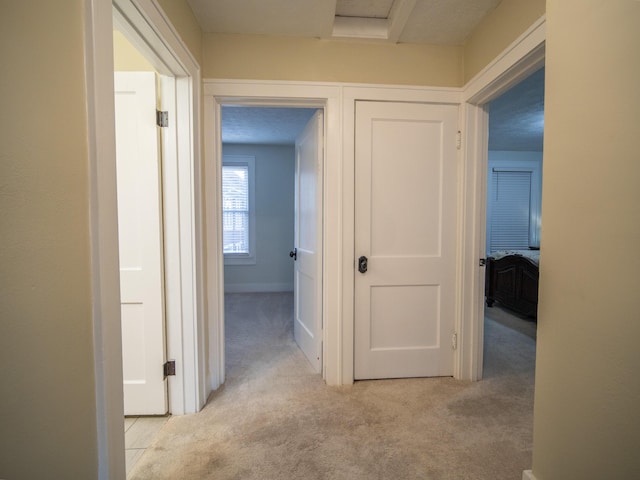 hall featuring light colored carpet