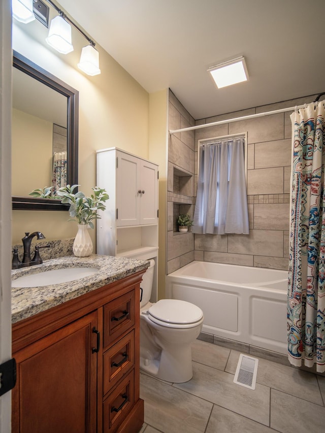 bathroom featuring visible vents, shower / tub combo with curtain, vanity, and toilet