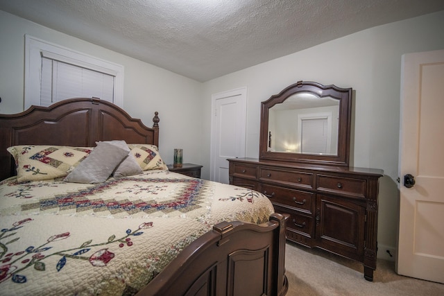 bedroom featuring a textured ceiling and light colored carpet