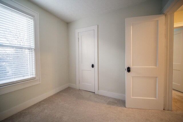 unfurnished bedroom featuring carpet floors and baseboards