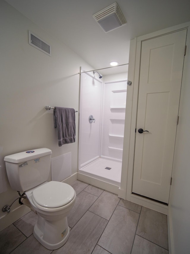 full bathroom with toilet, a stall shower, and visible vents