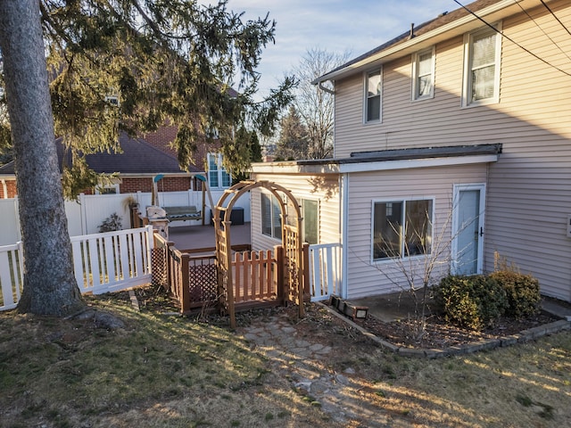 back of house with fence and a deck