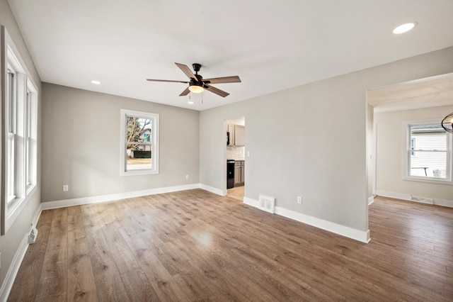 unfurnished living room with baseboards, plenty of natural light, visible vents, and light wood-style floors