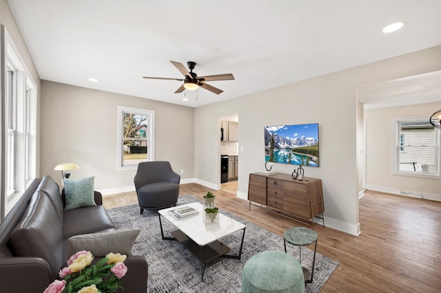 living area featuring light wood-style floors, recessed lighting, ceiling fan, and baseboards