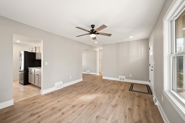 empty room with light wood finished floors, recessed lighting, visible vents, and baseboards