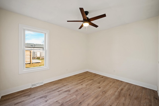 unfurnished room featuring visible vents, baseboards, and wood finished floors