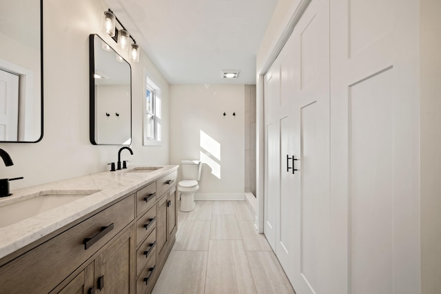 full bathroom with walk in shower, a sink, toilet, and double vanity