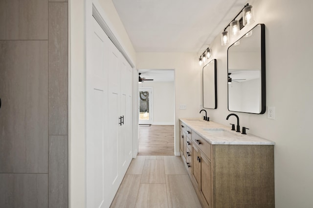 full bathroom with double vanity, a sink, and a ceiling fan