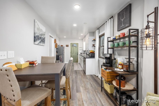 dining space with recessed lighting and light wood-style flooring