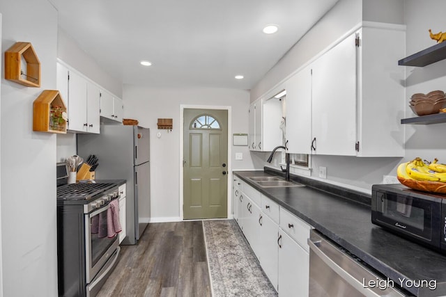 kitchen with open shelves, a sink, dark wood-style floors, white cabinetry, and appliances with stainless steel finishes