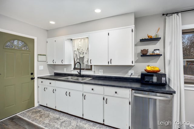 kitchen featuring dark countertops, open shelves, black microwave, stainless steel dishwasher, and a sink