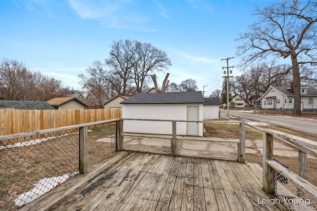 deck with a residential view, an outbuilding, and fence