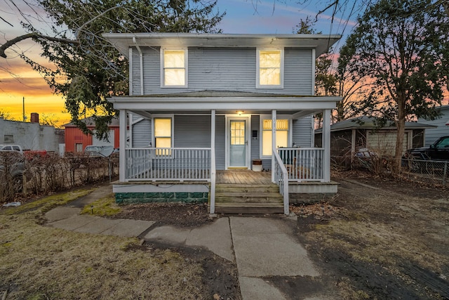 view of front of home with covered porch and fence