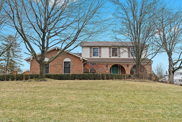 traditional-style home featuring a front yard and brick siding