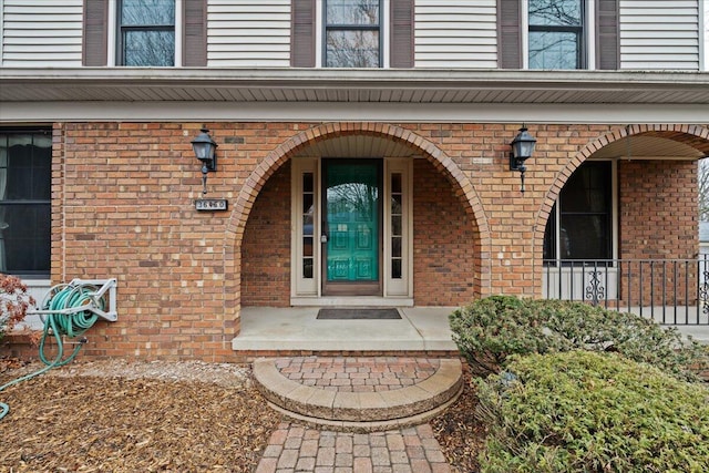 property entrance featuring brick siding and a porch