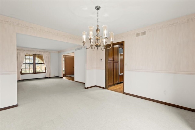 empty room featuring light carpet, visible vents, and baseboards