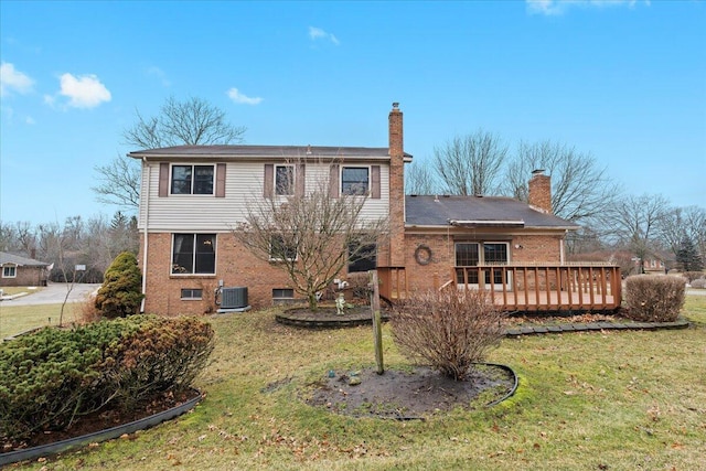 rear view of property with cooling unit, brick siding, a yard, and a chimney