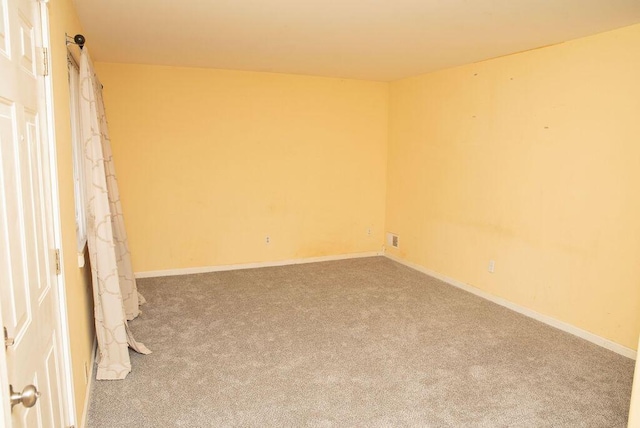 carpeted empty room featuring visible vents and baseboards