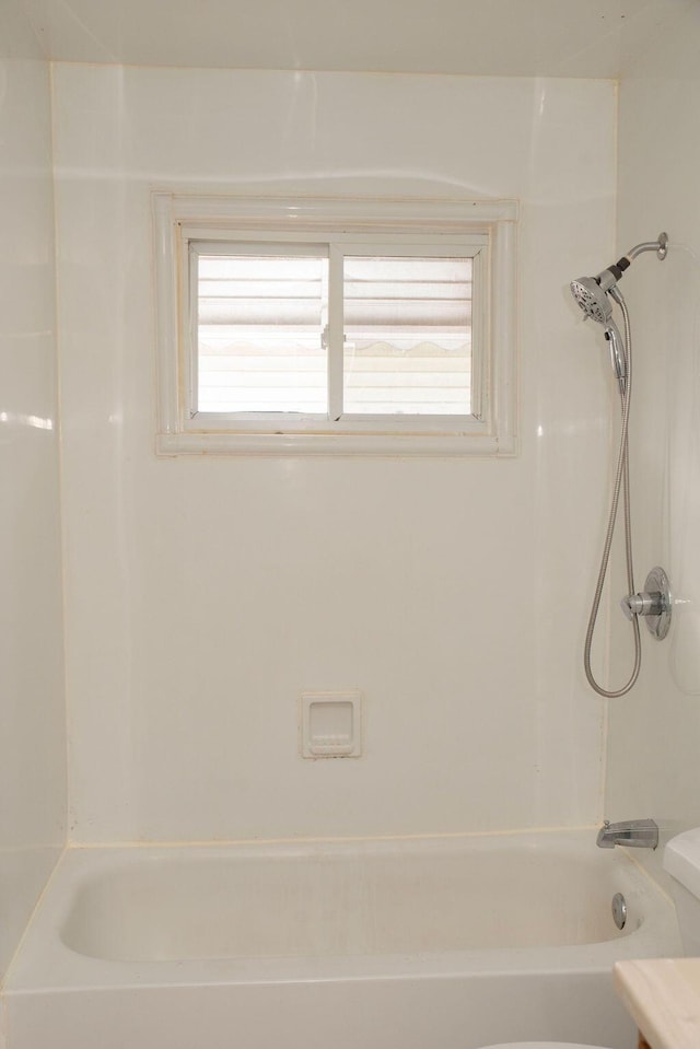 bathroom featuring plenty of natural light, toilet, and tub / shower combination