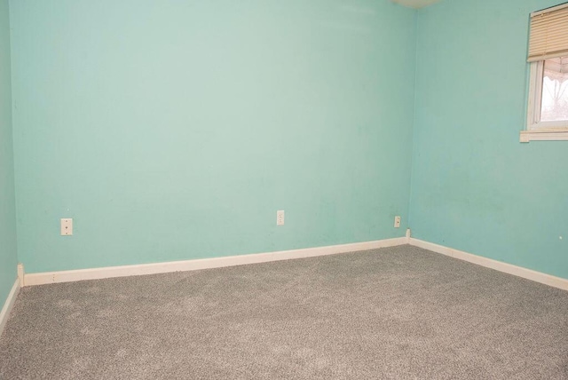 unfurnished room featuring carpet and baseboards