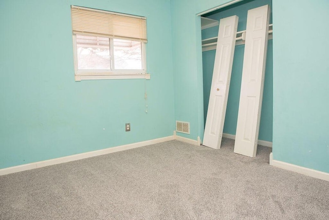 unfurnished bedroom with carpet, a closet, visible vents, and baseboards