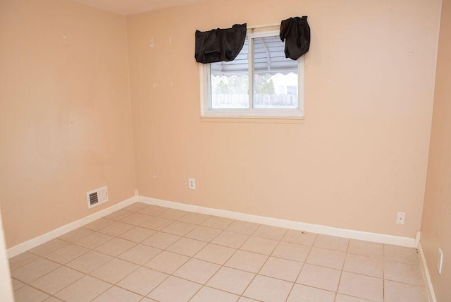 unfurnished room with baseboards and visible vents