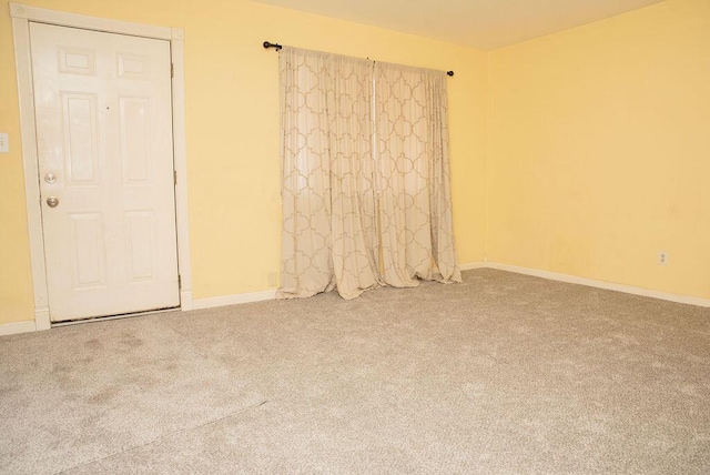 spare room with carpet and baseboards