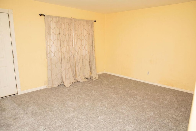 unfurnished room with carpet and baseboards