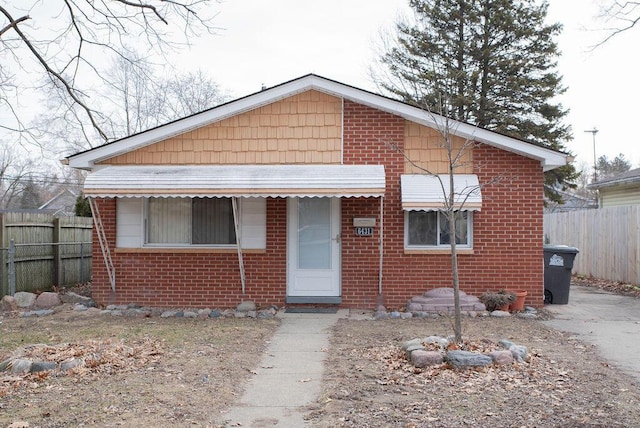 bungalow with brick siding and fence