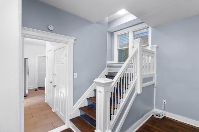 stairs with wood finished floors and baseboards