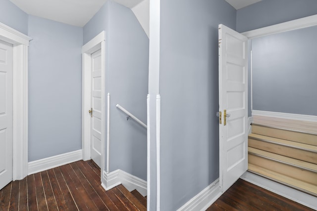 corridor with baseboards, an upstairs landing, and hardwood / wood-style flooring