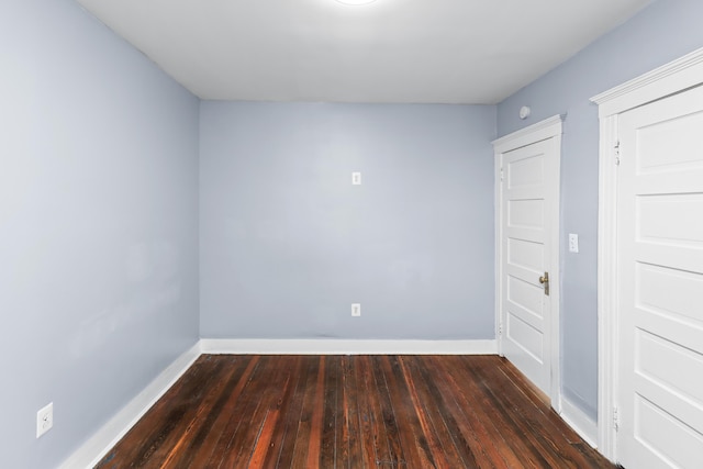 empty room featuring hardwood / wood-style flooring and baseboards