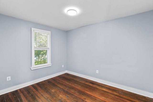 empty room featuring dark wood-style floors and baseboards