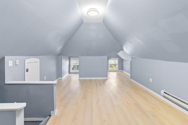 bonus room with vaulted ceiling, a baseboard radiator, light wood-style flooring, and baseboards