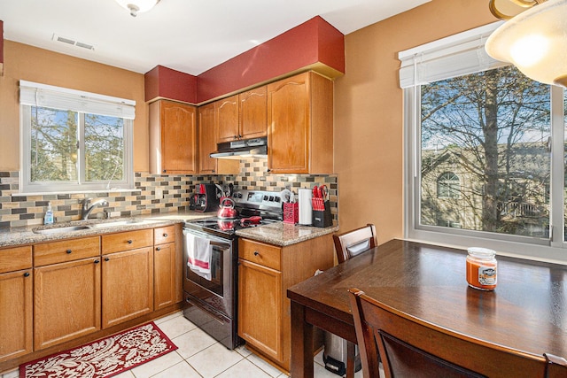 kitchen featuring electric range, visible vents, decorative backsplash, under cabinet range hood, and a sink