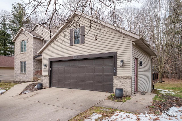 exterior space featuring stone siding and concrete driveway