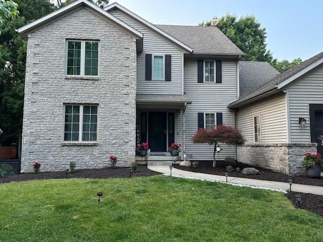 view of front of property featuring a shingled roof and a front lawn