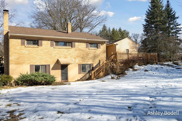 exterior space featuring a wooden deck, a chimney, stairway, and brick siding