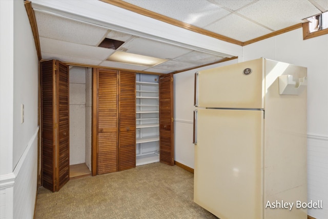 kitchen with carpet floors, a drop ceiling, and freestanding refrigerator