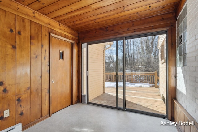 doorway featuring a baseboard heating unit, wood ceiling, wooden walls, and brick wall