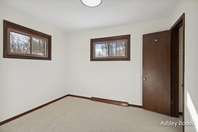 carpeted empty room with baseboards